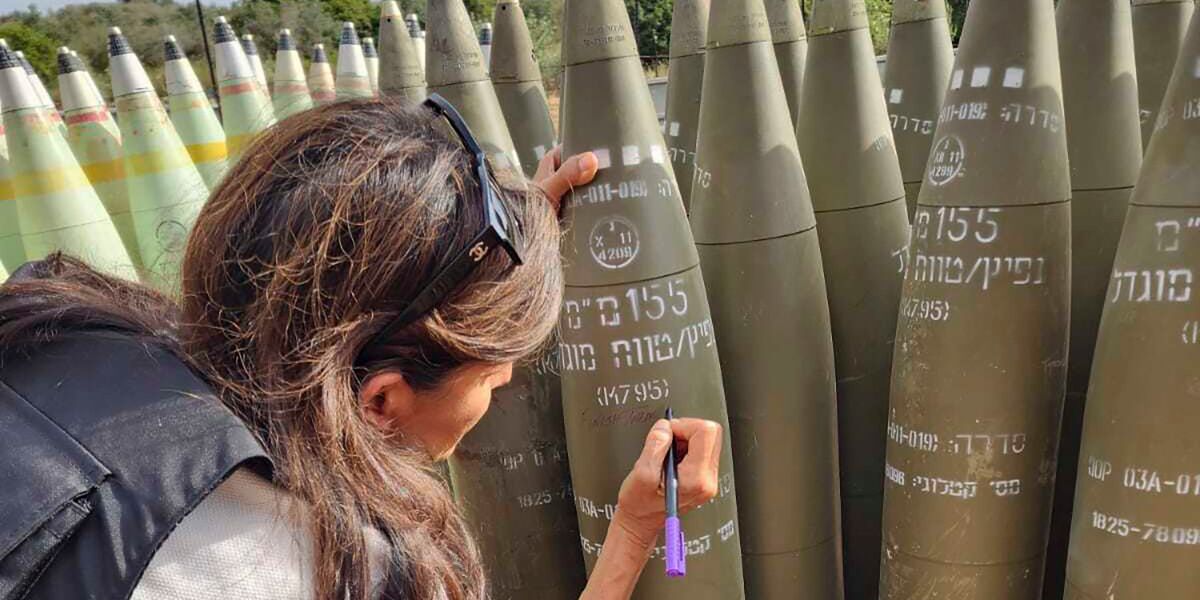 This photo provided by the Office of Israeli lawmaker Danny Danon, shows former U.S  Ambassador to the United Nations, Nikki Haley signing an Israeli artillery shell while touring Israel’s northern border with Lebanon on Tuesday, May 28, 2024.  Haley's visit comes as Israel faces heightened criticism for not doing enough to protect civilians in Gaza amid its war against Hamas, and days after Israeli airstrikes triggered a fire in a camp for displaced Palestinians that appeared to be one of the war’s deadliest attacks.  (Office of Israeli lawmaker Danny Danon via AP)