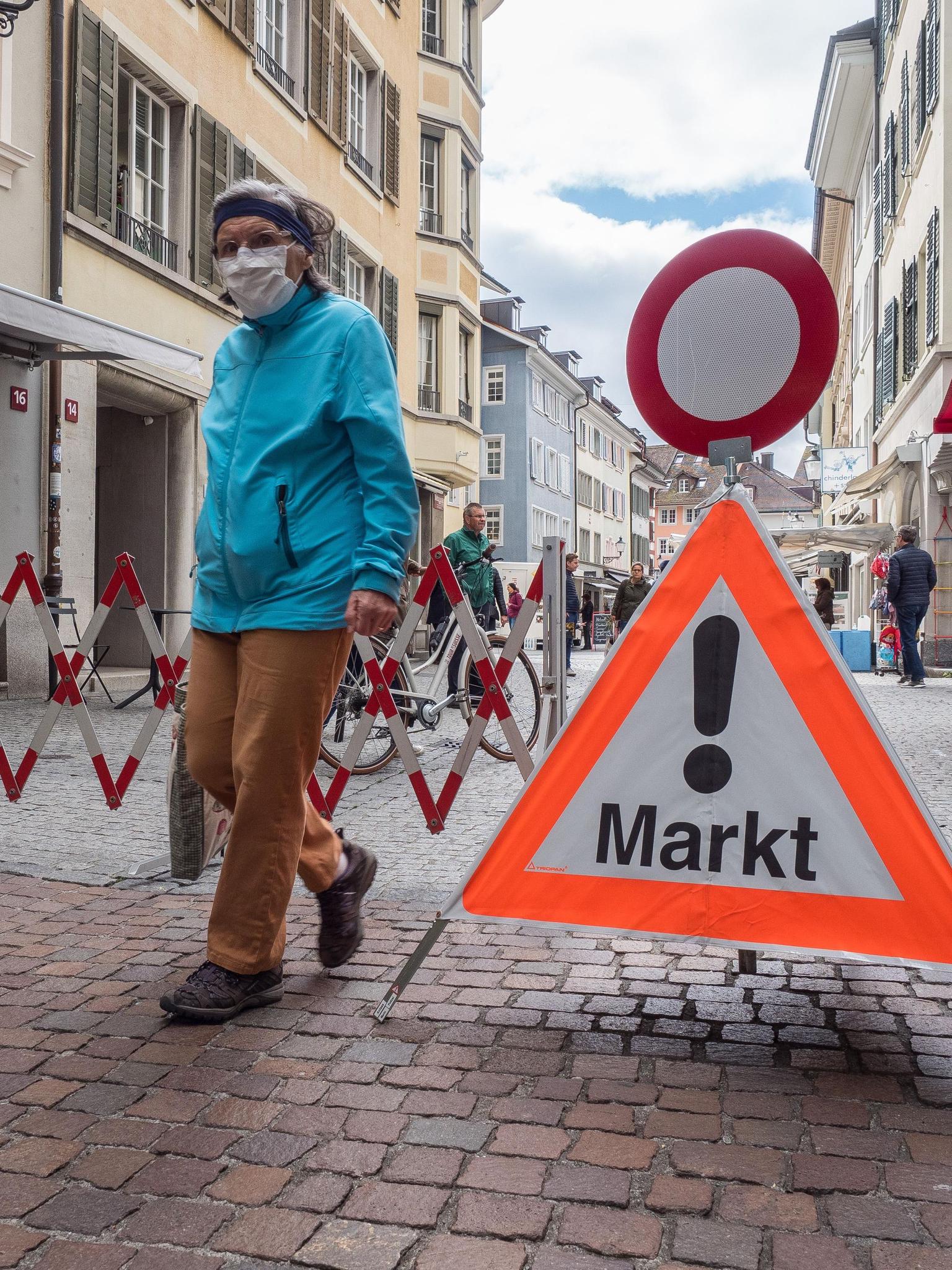 Einige Kundinnen und Kunden besuchen den Wochenmarkt nach dem Lockdown mit Schutzmaske. 