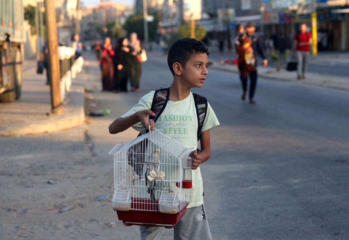 A Palestinian boy carries his pet bird in a cage as families leave their homes following an Israeli attack on the Rafah refugee camp, in the southern of Gaza Strip on Octobers 15, 2023. Thousands of people, both Israeli and Palestinians have died since October 7, 2023, after Palestinian Hamas militants based in the Gaza Strip, entered southern Israel in a surprise attack leading Israel to declare war on Hamas in Gaza on October 8. (Photo by MOHAMMED ABED / AFP)