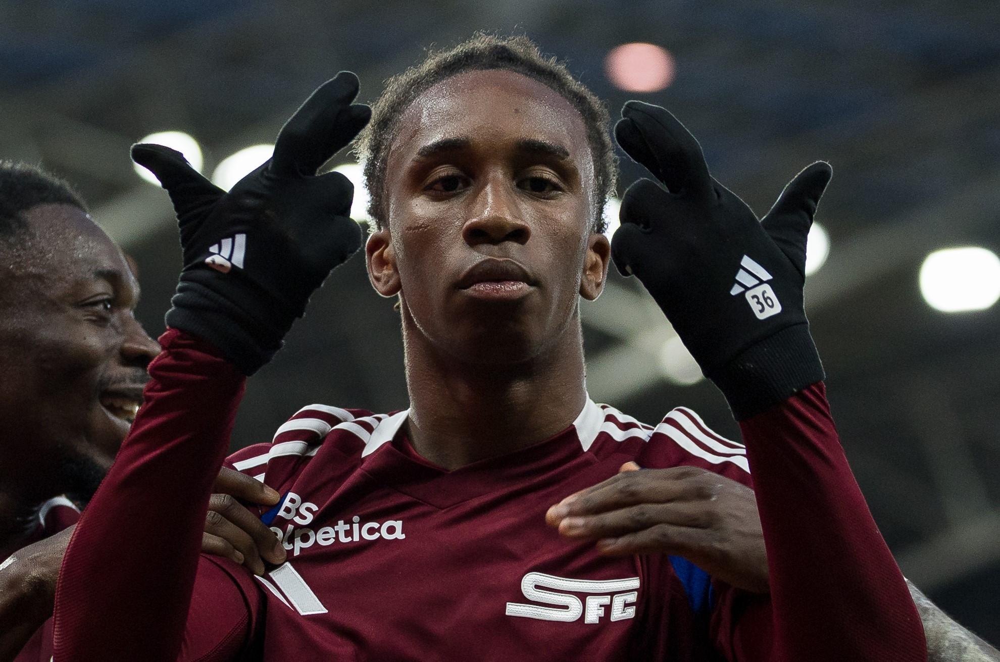 Joueur de football de l’équipe SFC célébrant un but contre Winterthour, 23 février 2025, vêtu d’un maillot bordeaux et portant des gants.